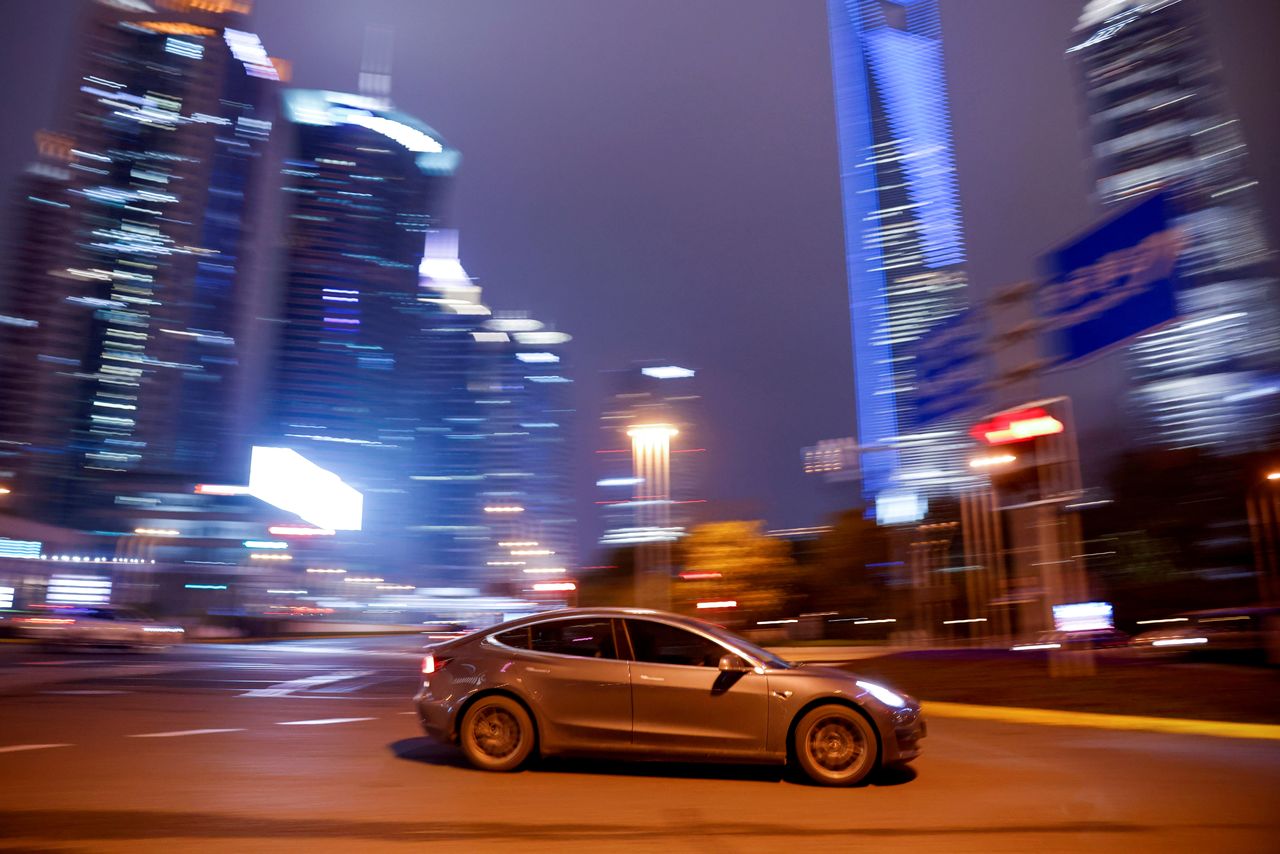 FILE PHOTO: A Tesla electric vehicle (EV) drives past a crossing in Shanghai, China March 9, 2021. REUTERS/Aly Song