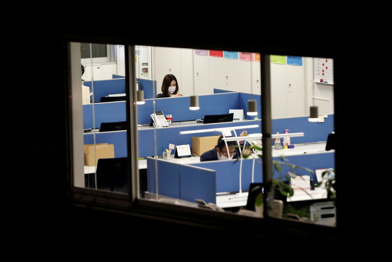 FILE PHOTO: Office workers wearing protective masks, following the coronavirus disease (COVID-19) outbreak, work at a business building in Tokyo, Japan November 27, 2020. REUTERS/Kim Kyung-Hoon/File Photo