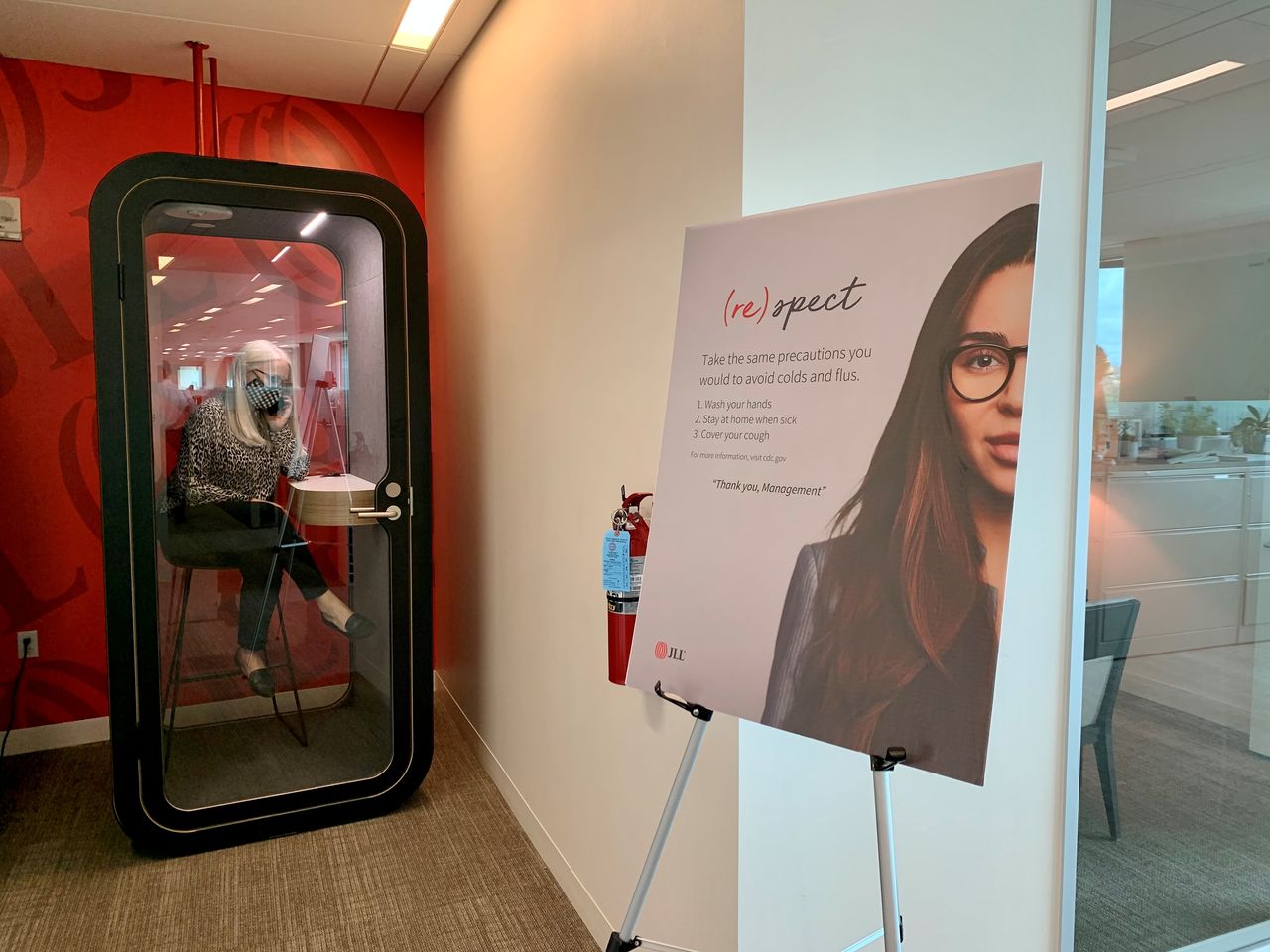 FILE PHOTO: An employee makes a call in a newly-installed phone booth at real estate company JLL