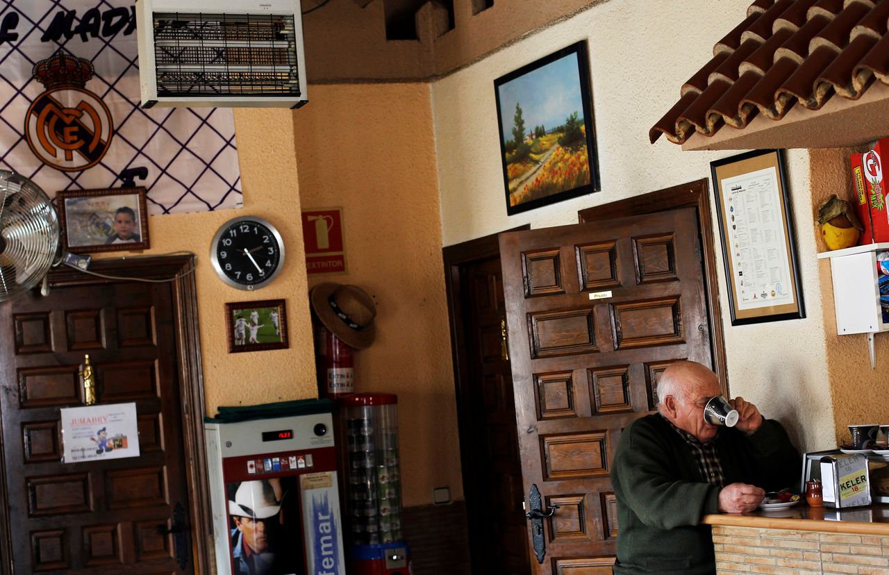 FILE PHOTO: A villager drinks coffee at the only bar in Peleas de Abajo, in northwestern Spain, March 8, 2012. REUTERS/Susana Vera