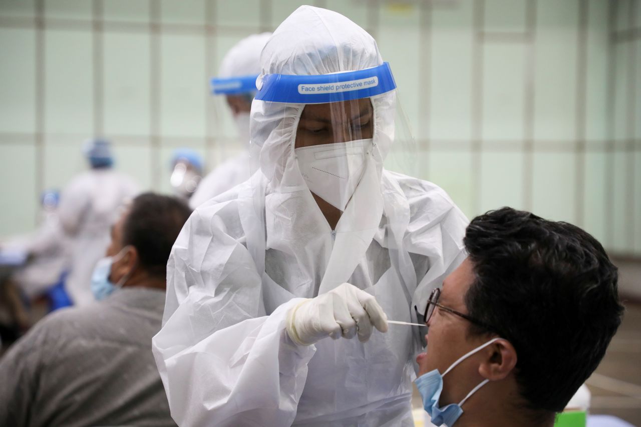 FILE PHOTO: A medical worker collects a swab sample from a man to be tested for the coronavirus disease (COVID-19) in Kuala Lumpur, Malaysia, May 11, 2021. REUTERS/Lim Huey Teng