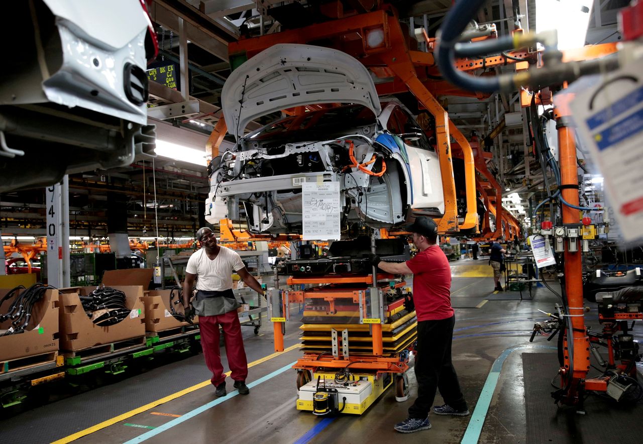 FILE PHOTO: General Motors assembly workers connect a battery pack underneath a partially assembled 2018 Chevrolet Bolt EV vehicle on the assembly line at Orion Assembly in Lake Orion, Michigan, U.S., March 19, 2018. REUTERS/Rebecca Cook