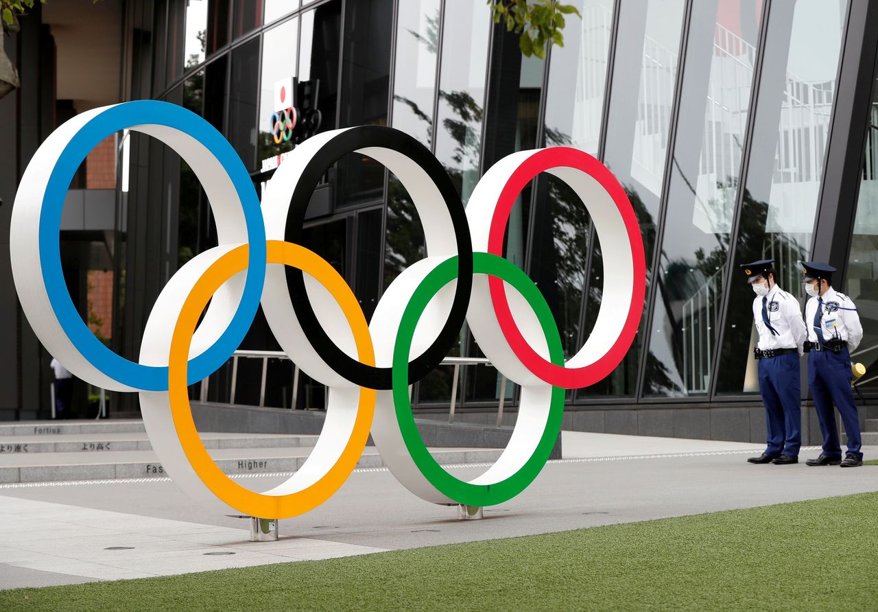 FILE PHOTO: Security personnel stand guard near the Olympic rings monument during a rally by anti-Olympics protesters outside the Japanese Olympic Committee headquarters, in Tokyo, Japan May 18, 2021. REUTERS/Issei Kato