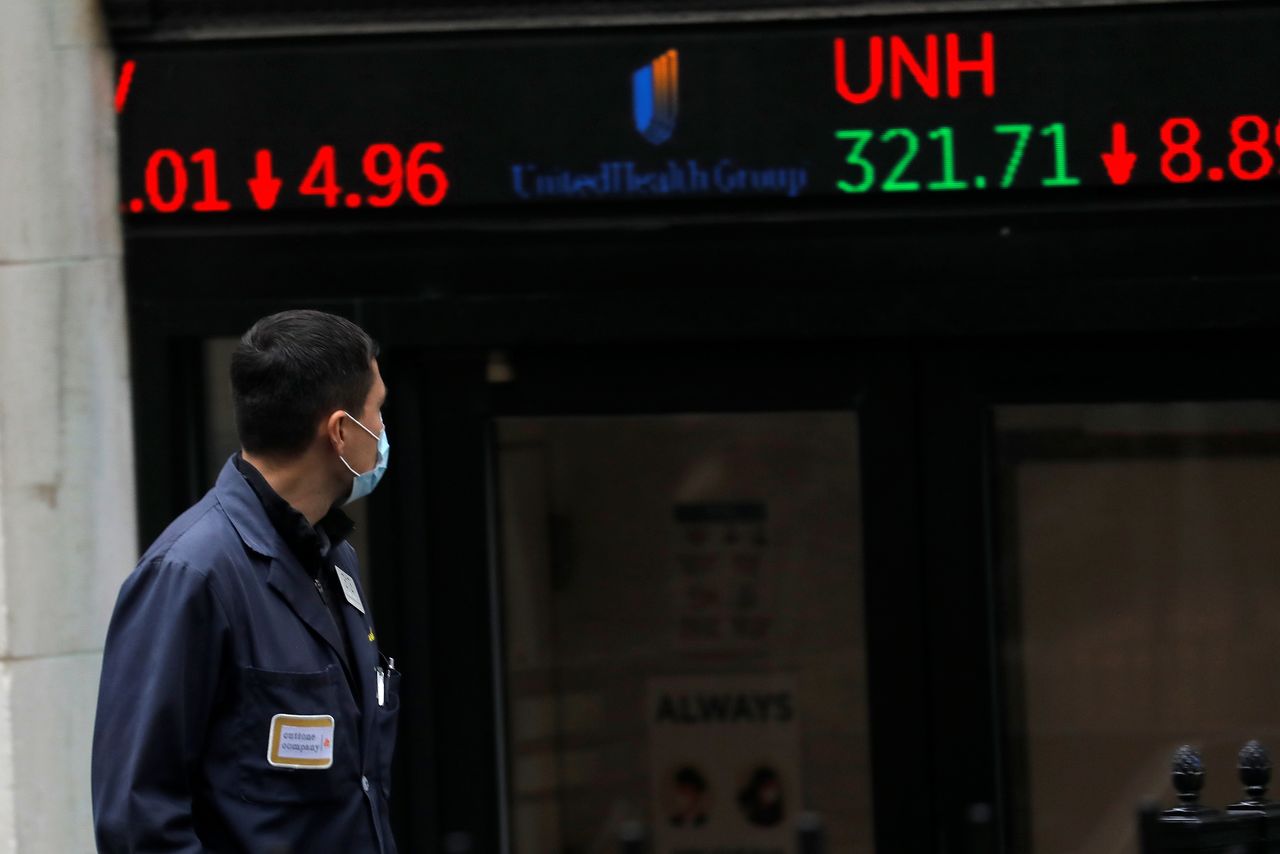 A trader walks past a digital stock price display outside the New York Stock Exchange in Manhattan in New York City, New York, U.S., October 26, 2020. REUTERS/Mike Segar