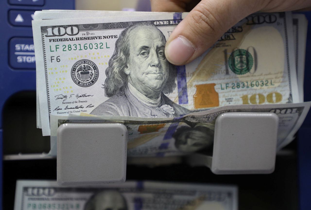FILE PHOTO: A man counts U.S. dollar banknotes at a currency exchange shop in Beirut, Lebanon March 23, 2021. REUTERS/Mohamed Azakir