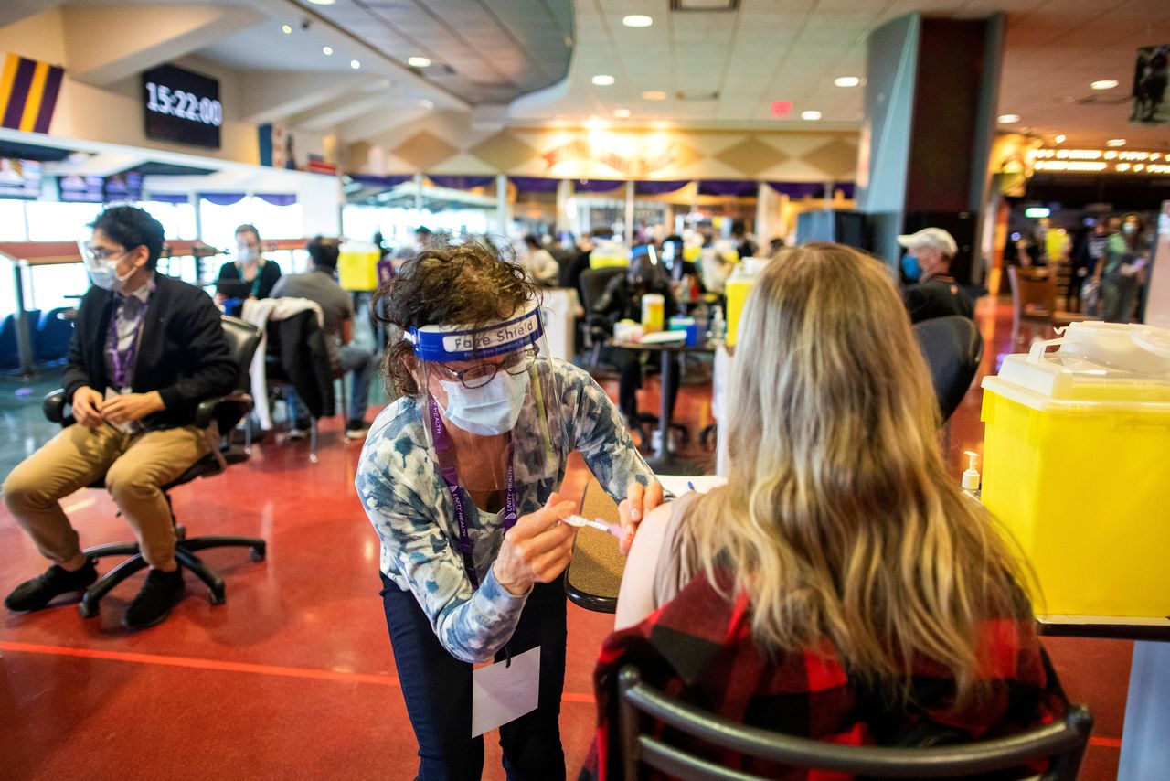 FILE PHOTO: A healthcare worker administers the Pfizer/BioNTech coronavirus disease (COVID-19) vaccine, which was authorized by Canada to be used for children aged 12 to 15, at Woodbine Racetrack pop-up vaccine clinic in Toronto, Ontario, Canada May 5, 2021. REUTERS/Carlos Osorio/File Photo