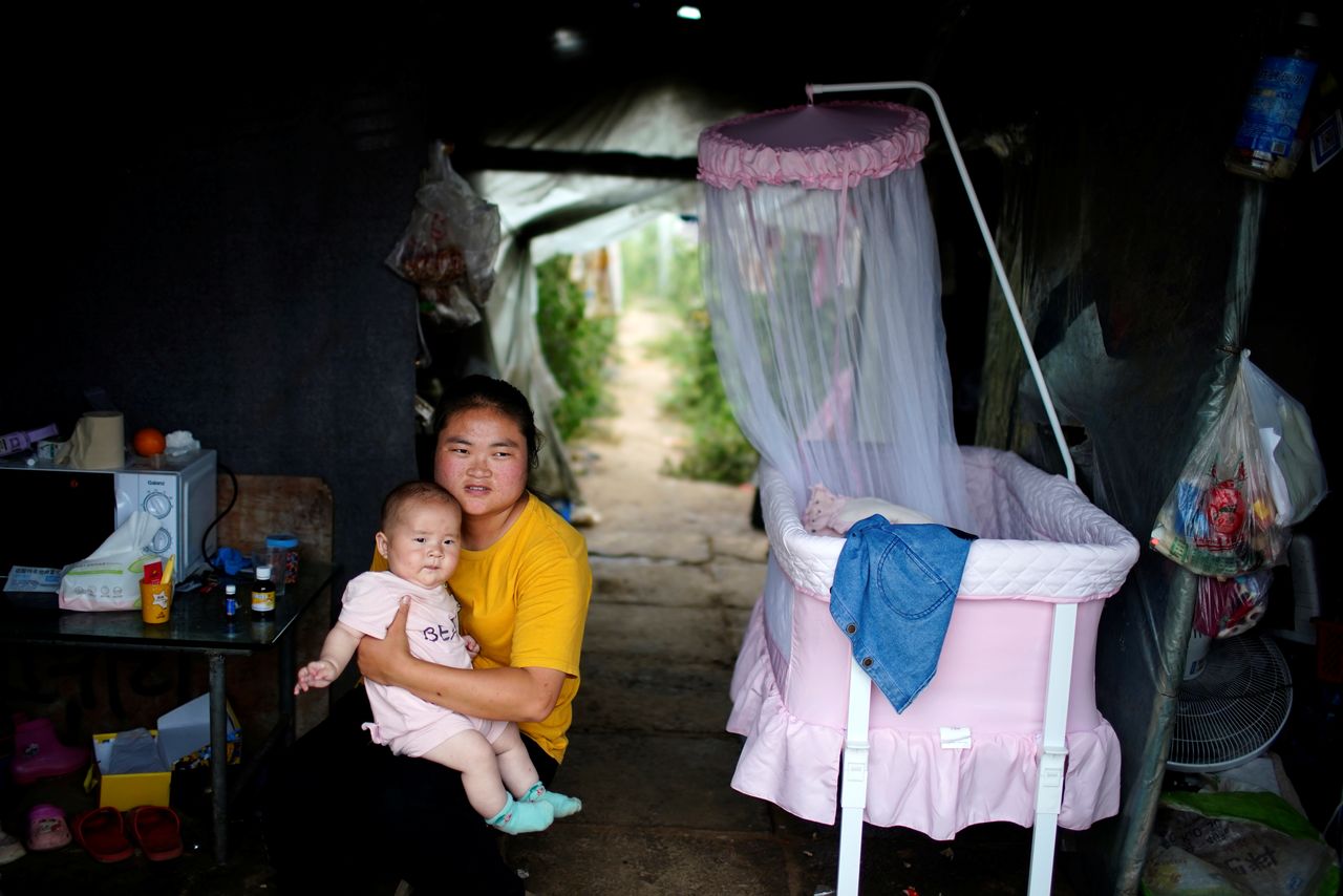 Wang Dan, 27, poses for her 5-month-old baby inside a room of a greenhouse at a village on the outskirts of Shanghai, China June 3, 2021. REUTERS/Aly Song