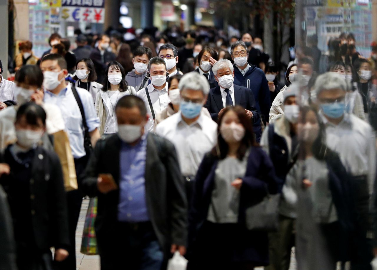FILE PHOTO: People wearing protective face masks walk on the street, amid the coronavirus disease (COVID-19) outbreak, in Tokyo, Japan November 19, 2020. REUTERS/Issei Kato