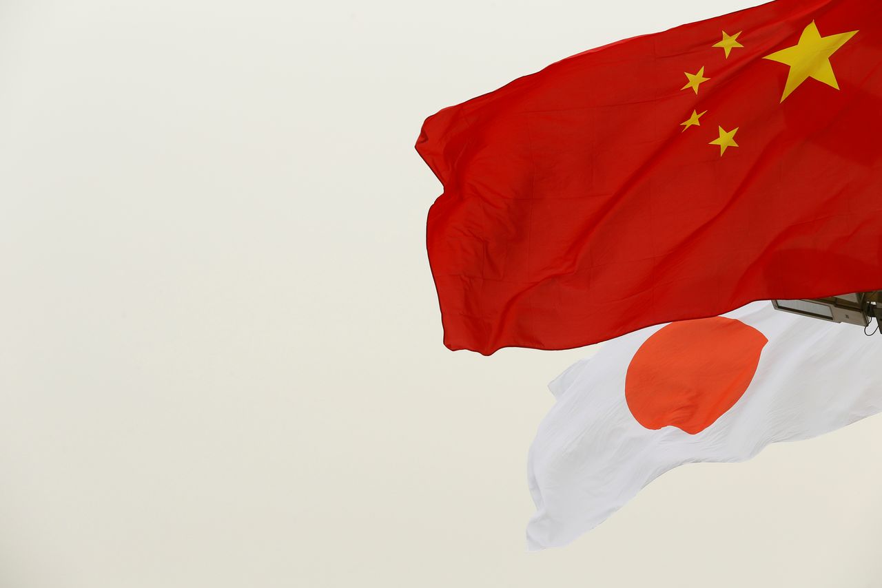 FILE PHOTO: Chinese and Japanese flags flutter in front of the Tiananmen Gate ahead of Japan
