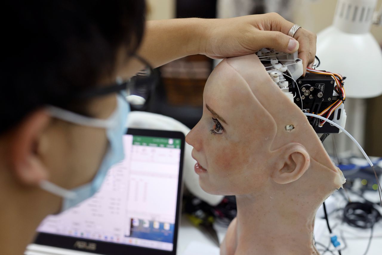 An engineer adjusts the head of humanoid robot Grace, developed by Hanson Robotics and designed for the healthcare market, to interact and comfort the elderly and isolated people, especially those suffering during the coronavirus disease (COVID-19) pandemic, at the company