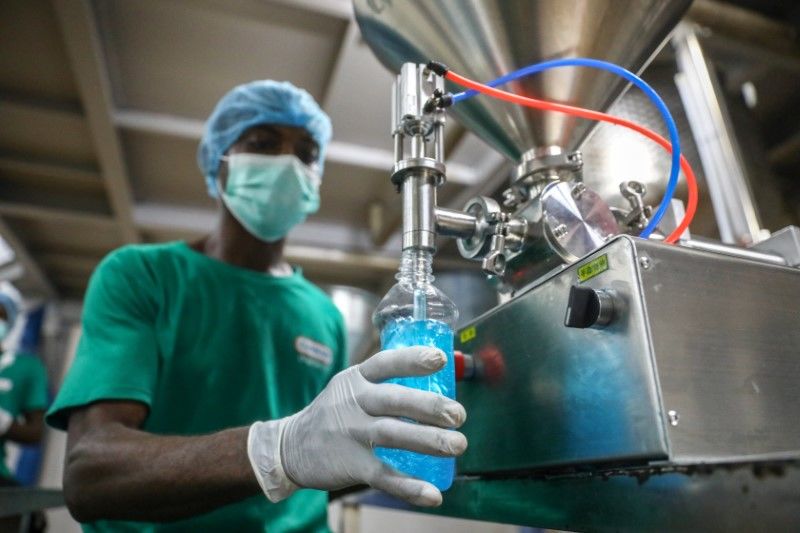FILE PHOTO: An employee fills a bottle with hand sanitizer in Cormart factory as the company steps up production of hand sanitizers to prevent the spread of coronavirus disease (COVID-19), on the outskirts of Lagos, Nigeria March 19, 2020. Picture taken March 19, 2020. REUTERS/Temilade Adelaja