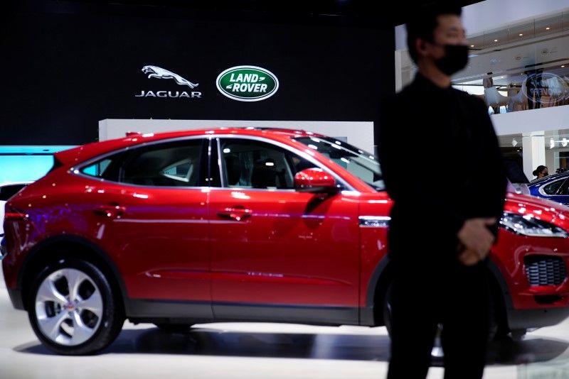 FILE PHOTO: A staff member stands at the Jaguar Land Rover booth during a media day for the Auto Shanghai show in Shanghai, China April 20, 2021. REUTERS/Aly Song