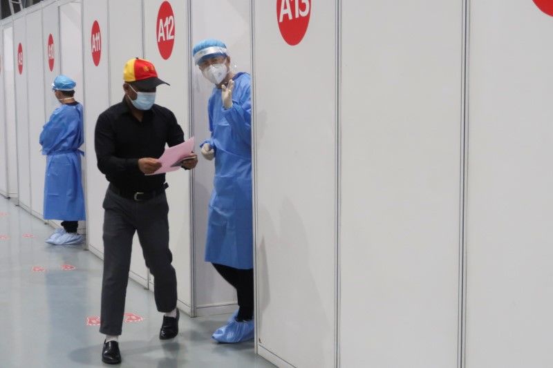 FILE PHOTO: A man leaves a booth to after receiving a coronavirus disease (COVID-19) vaccine at a vaccination center, during a government-organized visit, in Beijing, China, April 15, 2021. REUTERS/Thomas Peter