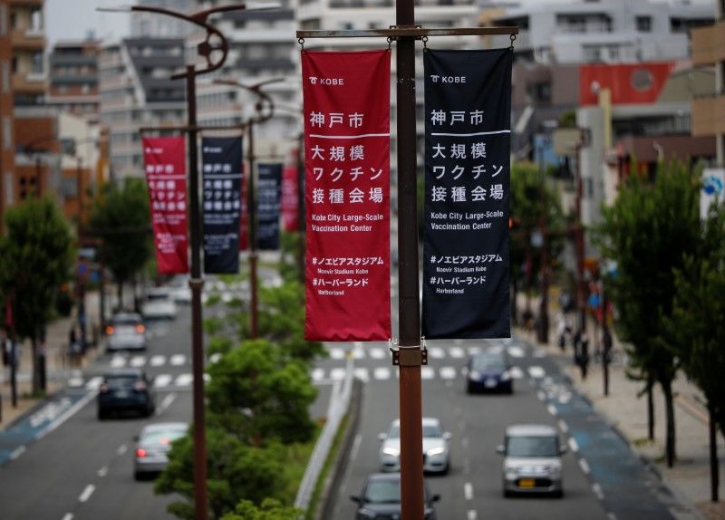 FILE PHOTO: Banners guiding to large-scale COVID-19 vaccination centers are displayed along the street in Kobe, Japan June 12, 2021. REUTERS/Issei Kato/File Photo