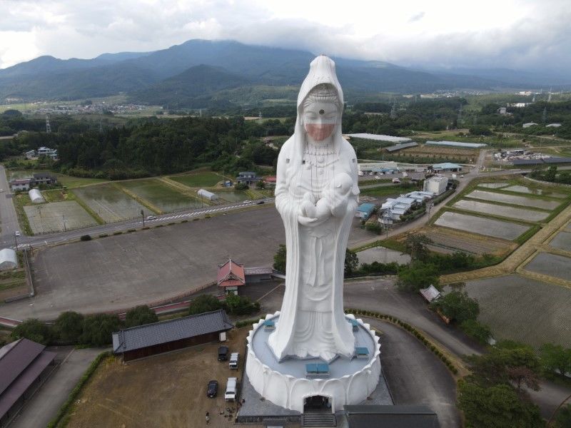 A drone picture shows a mask placed on a 57-metre-high statue of Buddhist goddess Kannon to pray for the end of the coronavirus disease (COVID-19) pandemic at Houkokuji Aizu Betsuin temple in Aizuwakamatsu, Fukushima Prefecture, Japan in this handout photo taken on June 15 2021. OISO ALL SUPPORT/Handout via REUTERS