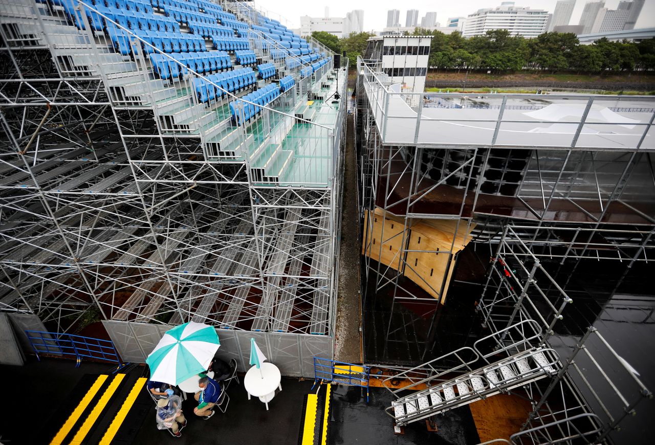 FILE PHOTO: Officials pause during a seeding run event interrupted by the rain at the Tokyo 2020 Olympics Cycling BMX test event at Ariake Urban Sports Park in Tokyo, Japan May 17, 2021. REUTERS/Issei Kato