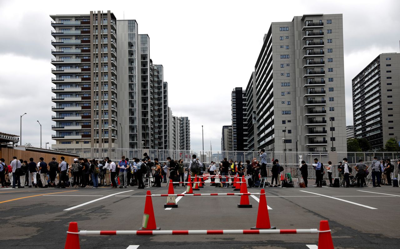 Journalists stand in a line to enter the village plaza of the Tokyo 2020 Olympic and Paralympic Village for a press tour in Tokyo, Japan, June 20, 2021. REUTERS/Kim Kyung-Hoon