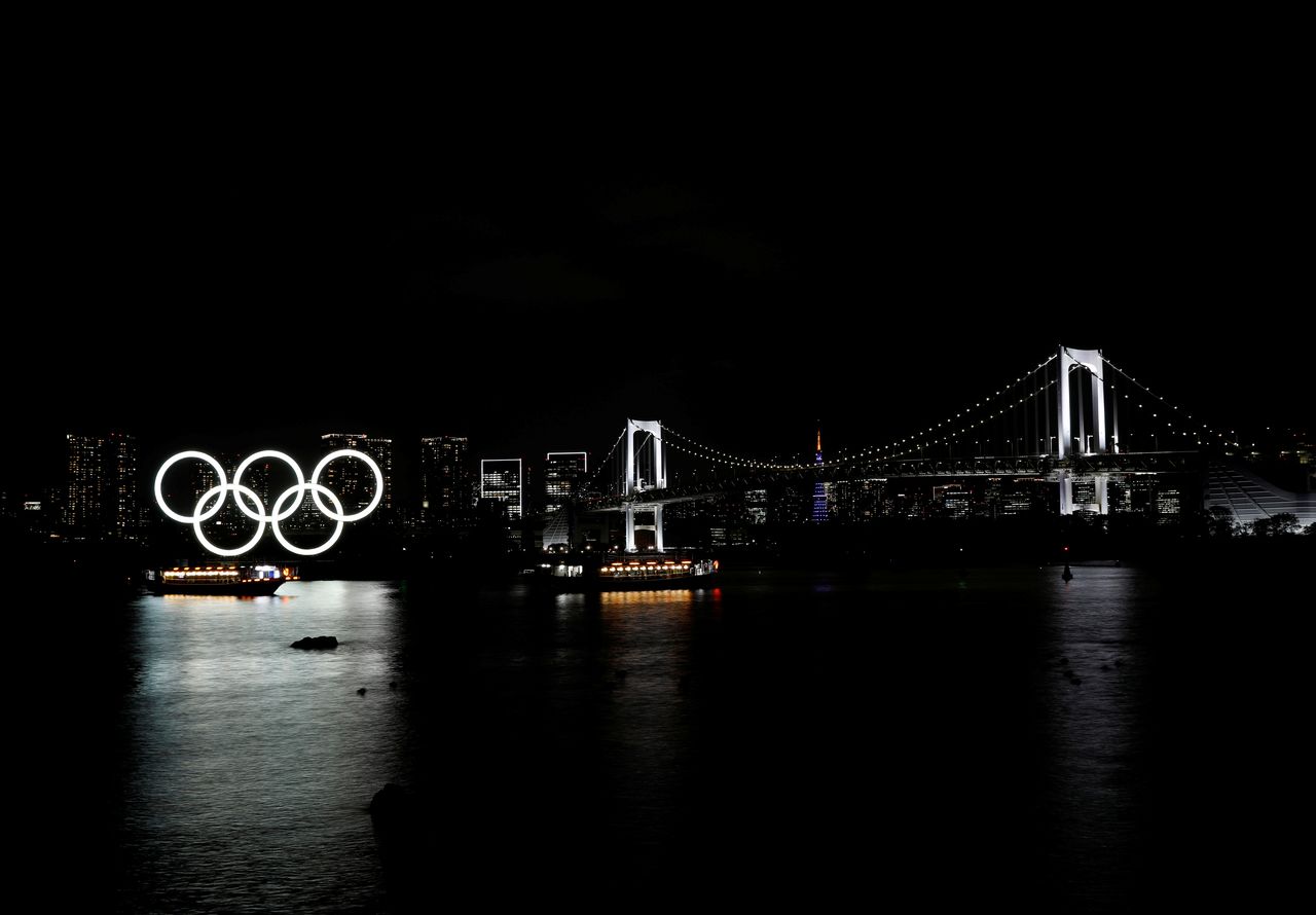 Boats sail past the giant Olympic rings and the Rainbow Bridge on the waterfront area of Odaiba Marine Park in Tokyo, Japan, April 2, 2021. REUTERS/Kim Kyung-Hoon