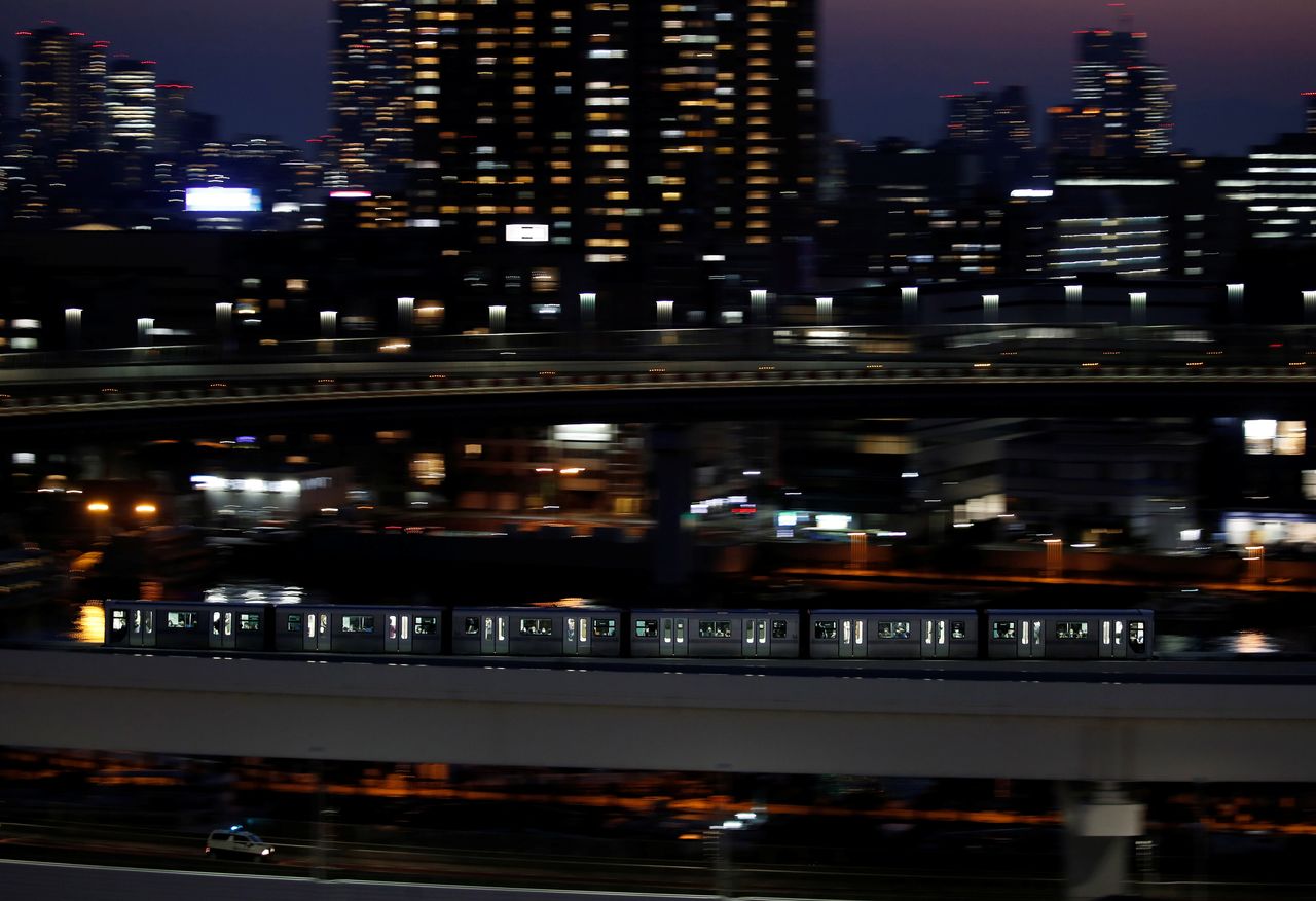 A Yurikamome line train, a driverless automatic train system, travels past buildings in Tokyo, Japan, April 21, 2021. Picture taken with a slow shutter speed. REUTERS/Kim Kyung-Hoon
