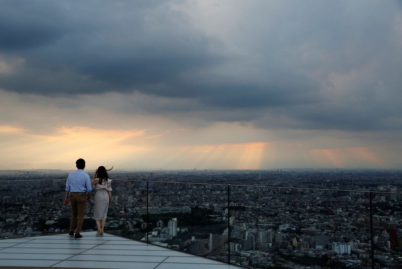 Visitors look at the skyline as they stand on Shibuya Sky, the observation deck of Shibuya Scramble Square, in Tokyo, Japan, June 1, 2021. REUTERS/Kim Kyung-Hoon