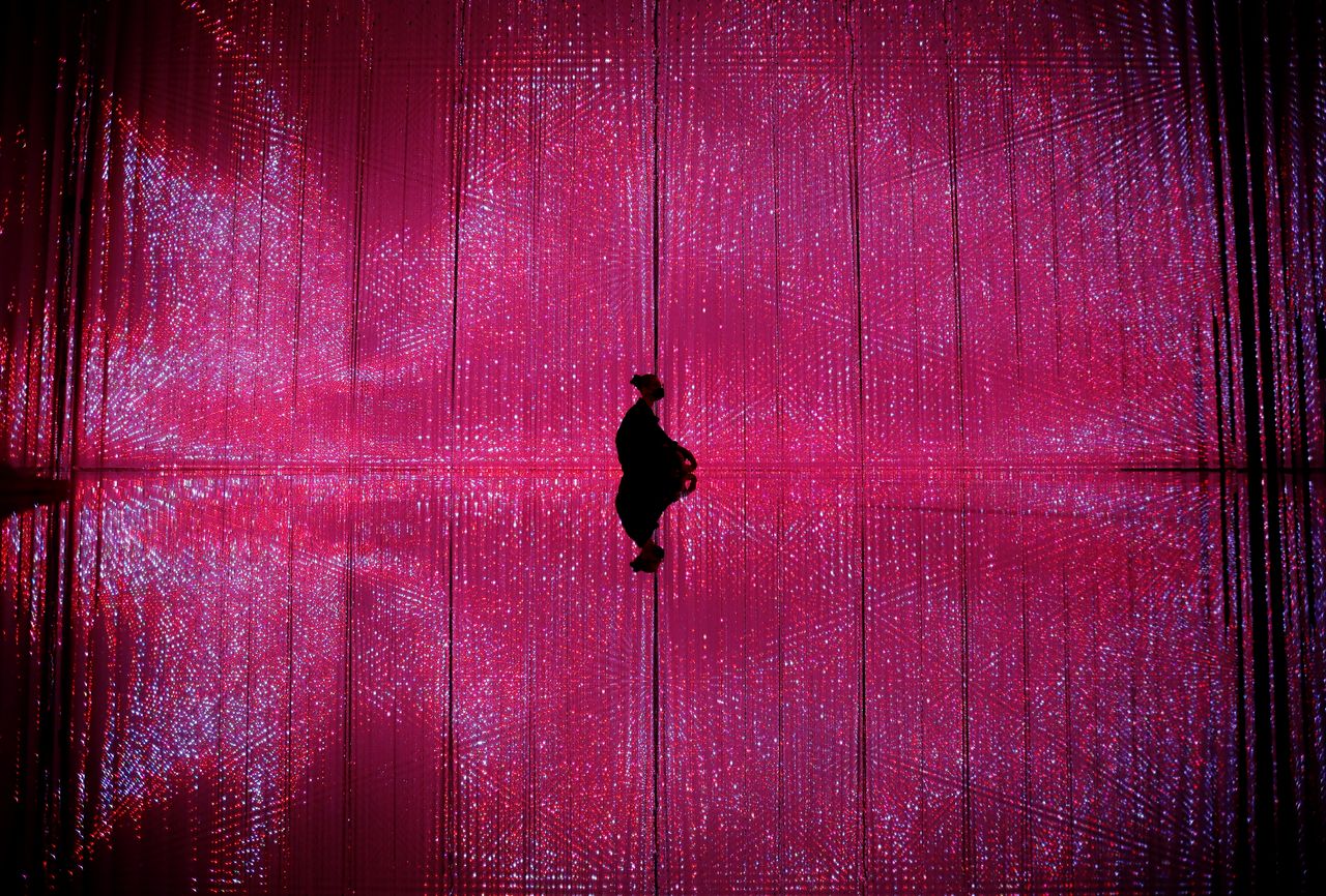 A teamLab staff member poses for a photograph as he sits inside a digital artwork at teamLab Planets in Tokyo, Japan, June 3, 2021. REUTERS/Kim Kyung-Hoon