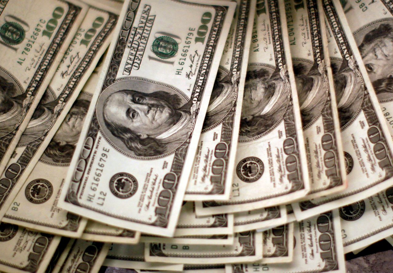 FILE PHOTO: Four thousand U.S. dollars are counted out by a banker counting currency at a bank in Westminster, Colorado November 3, 2009. REUTERS/Rick Wilking/File Photo