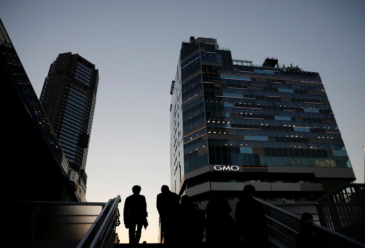 Pedestrians make their way at a business district in Tokyo, Japan, December 7, 2020. REUTERS/Kim Kyung-Hoon/Files