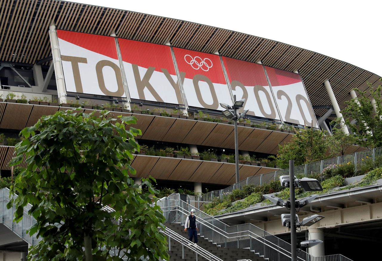 A construction worker is seen at Olympic Stadium (National Stadium), main stadium for Tokyo 2020 Olympic Games that have been postponed to 2021 due to the COVID-19 pandemic, in Tokyo, Japan June 23, 2021, on the day to mark one month to go until the opening of the Olympic Games. REUTERS/Issei Kato