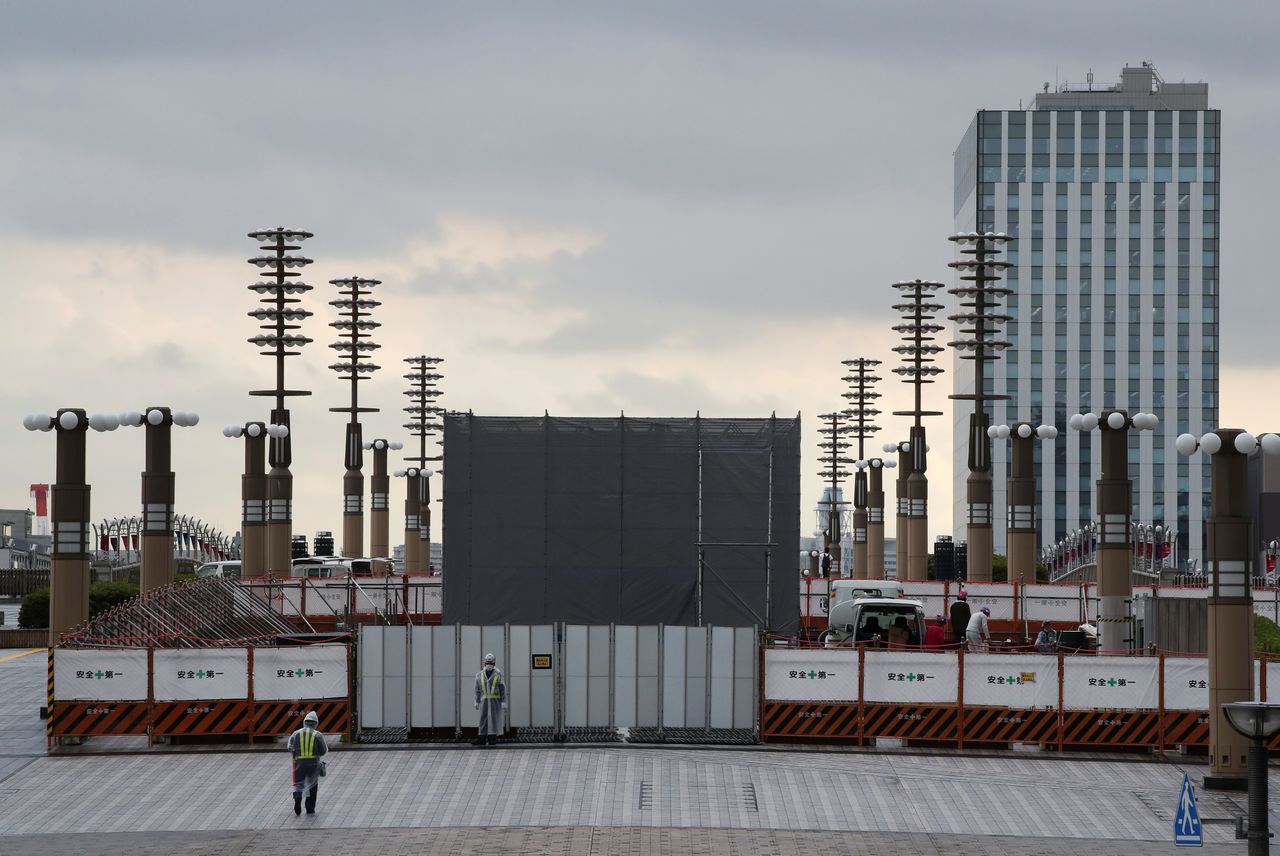 People work at the construction site to set up the second cauldron where the Tokyo 2020 Olympic Games torch will be placed during the Olympic Games, one month ahead of the opening of the games in Tokyo, Japan, June 23, 2021. REUTERS/Kim Kyung-Hoon