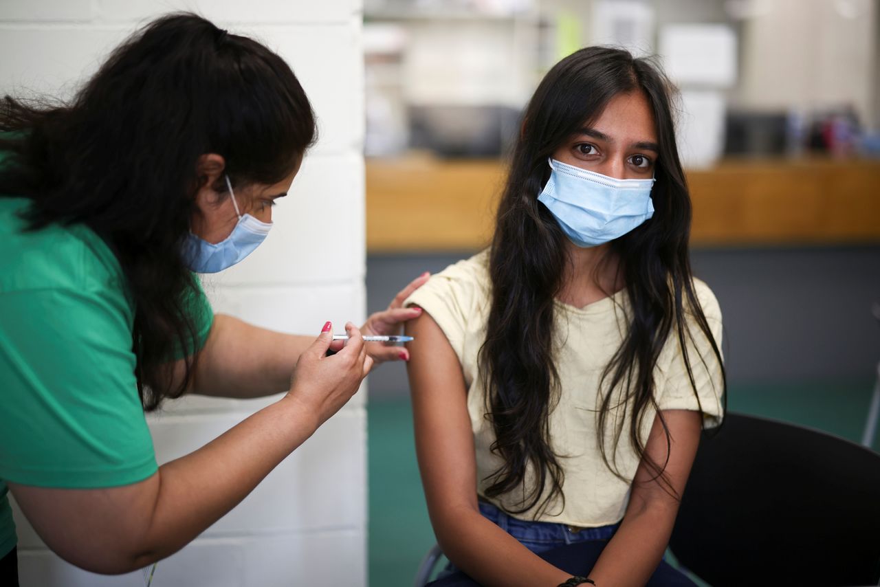 FILE PHOTO: A person receives a dose of the Pfizer BioNTech vaccine at a vaccination centre for those aged over 18 years old at the Belmont Health Centre in Harrow, amid the coronavirus disease (COVID-19) outbreak in London, Britain, June 6, 2021. REUTERS/Henry Nicholls