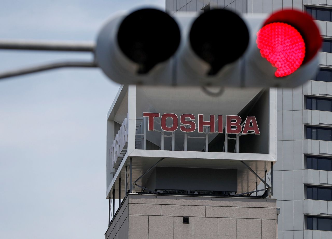 FILE PHOTO: The logo of Toshiba Corp. is seen next to a traffic signal atop of a building in Tokyo, Japan June 11, 2021. REUTERS/Issei Kato/File Photo