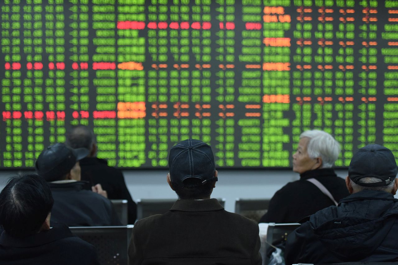 Investors sit in front of a board showing stock information at a brokerage house on the first day of trade in China since the Lunar New Year, in Hangzhou, Zhejiang province, China February 3, 2020. China Daily via REUTERS/Files