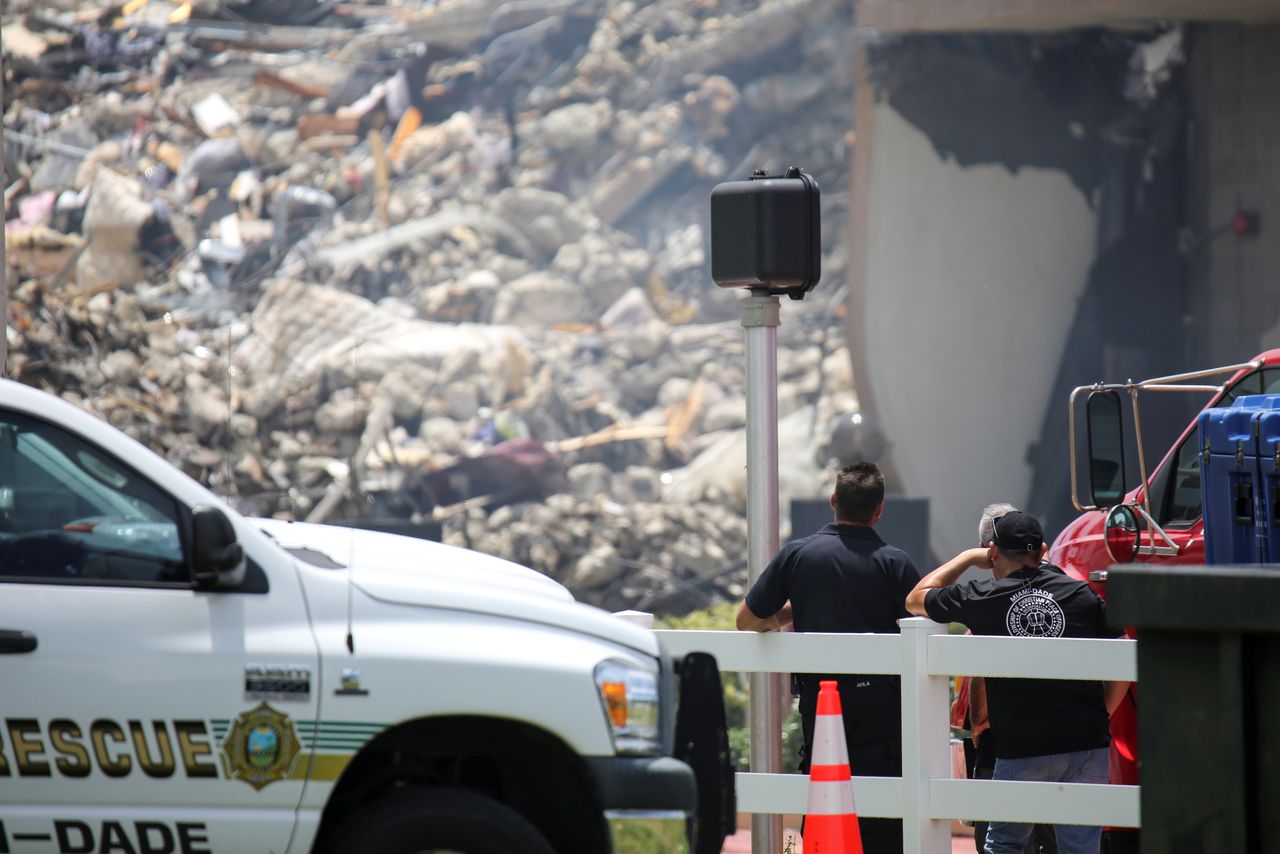 Rescue workers look at the debris of a partially collapsed residential building as the emergency crews continue search and rescue operations for survivors, in Surfside, near Miami Beach, Florida, U.S. June 26, 2021. REUTERS/Marco Bello