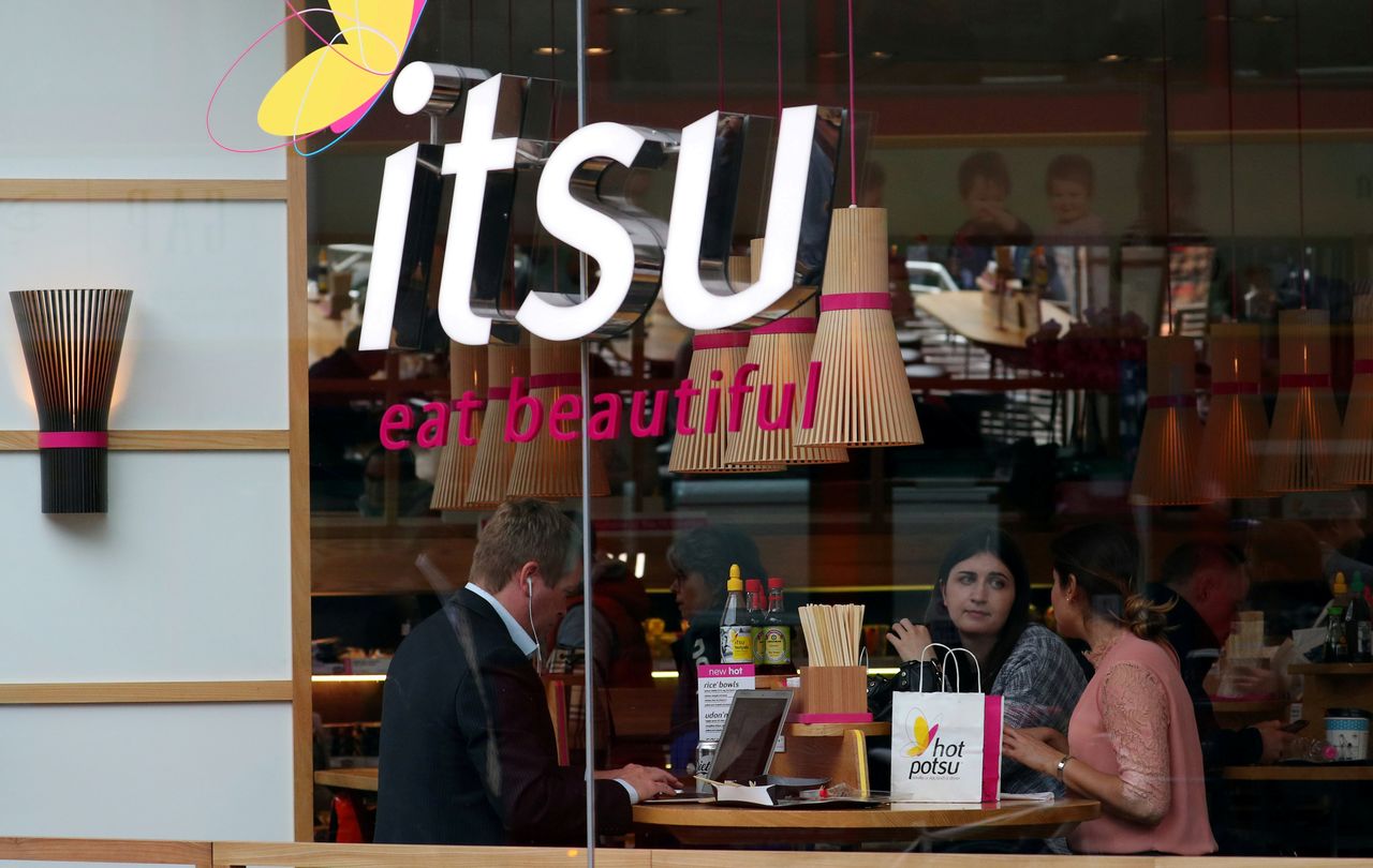 FILE PHOTO: Customers eat inside an Itsu restaurant, a company in which private-equity firm Bridgepoint is invested, in London, Britain, September 25, 2017. REUTERS/Hannah McKay
