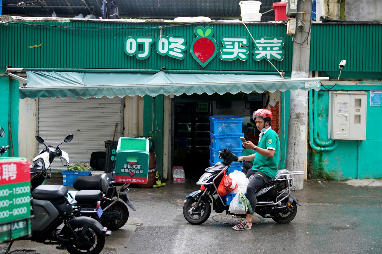 A delivery worker of Chinese online grocery Dingdong Maicai works at a shop on a street in Shanghai, China June 10, 2021. REUTERS/Aly Song/Files