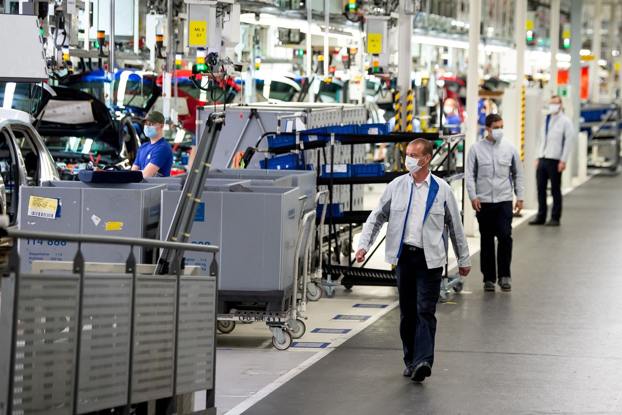 FILE PHOTO: Staff wear protective masks at the Volkswagen assembly line in Wolfsburg, Germany, April 27, 2020. Swen Pfoertner/Pool via REUTERS