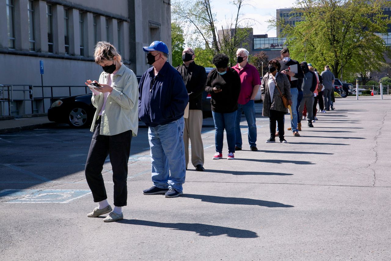 FILE PHOTO: People line up outside a newly reopened career center for in-person appointments in Louisville, U.S., April 15, 2021. REUTERS/Amira Karaoud