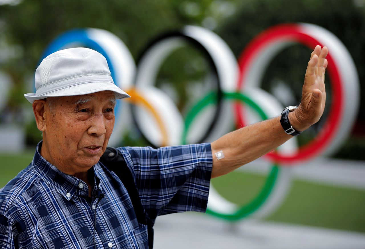 Kohei Jinno, 87, who was forced to leave his house two times ahead of the 1964 and 2020 Olympics Games to make way for construction of the main stadium, speaks in front of the Olympic Rings monument outside the Japan Olympic Museum near the National Stadium, the main stadium for the 2020 Tokyo Olympic Games that have been postponed to 2021 due to the coronavirus disease (COVID-19) pandemic, in Tokyo, Japan June 24, 2021. REUTERS/Issei Kato