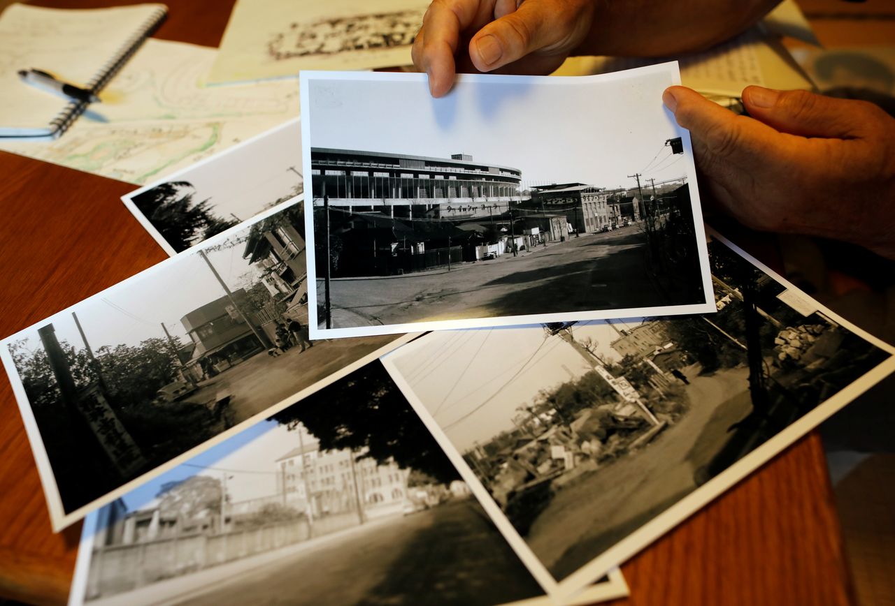 Kohei Jinno, 87, who was forced to leave his house two times ahead of the 1964 and 2020 Olympics Games to make way for construction of the main stadium, shows his old photos of previous national stadium neighbouring taken in around 1960th, at his house, in Tokyo, Japan June 24, 2021. REUTERS/Issei Kato