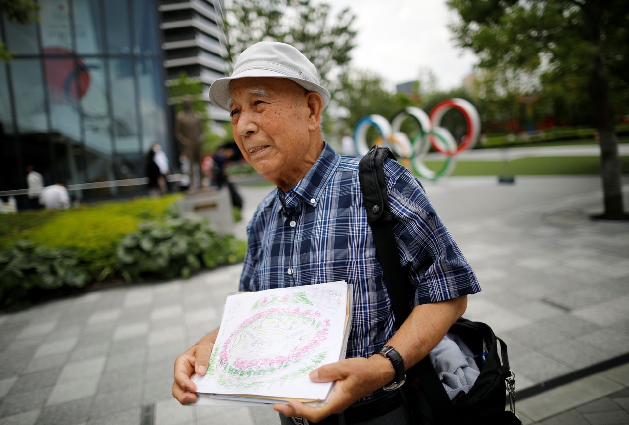 Kohei Jinno, 87, who was forced to leave his house two times ahead of the 1964 and 2020 Olympics Games to make way for construction of the main stadium, speaks in front of the Olympic Rings monument outside the Japan Olympic Museum near the National Stadium, the main stadium for the 2020 Tokyo Olympic Games that have been postponed to 2021 due to the coronavirus disease (COVID-19) pandemic, in Tokyo, Japan June 24, 2021. REUTERS/Issei Kato