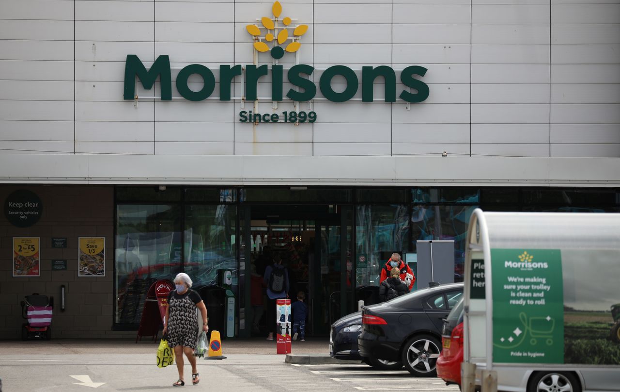 A customer carries a shopping bag outside a Morrisons supermarket in New Brighton, Britain, July 5, 2021. REUTERS/Phil Noble