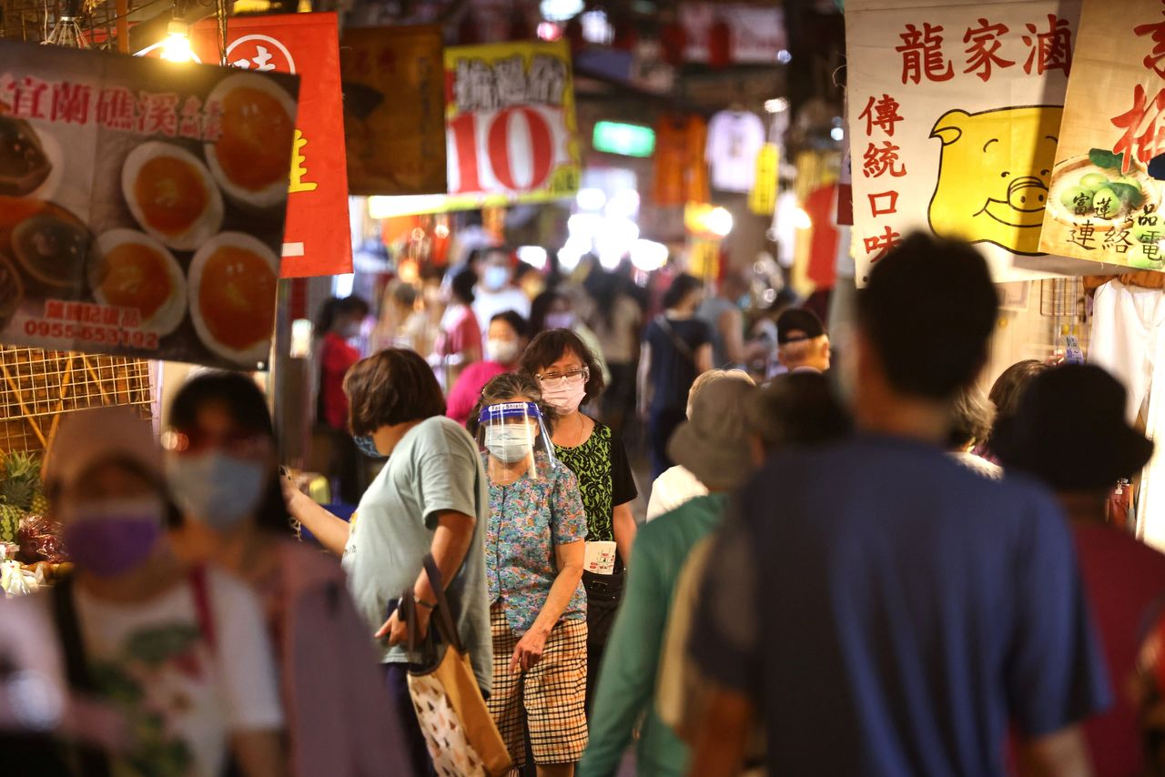 FILE PHOTO: People wearing protective face masks shop at a market amid the coronavirus disease (COVID-19) pandemic, in Taipei, Taiwan, July 6, 2021. REUTERS/Ann Wang