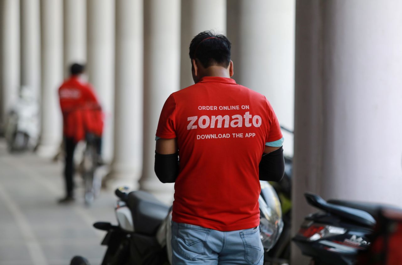 FILE PHOTO: A delivery worker of Zomato, an Indian food-delivery startup, waits to collect an order from a restaurant in New Delhi, India, May 21, 2020. REUTERS/Anushree Fadnavis/File Photo