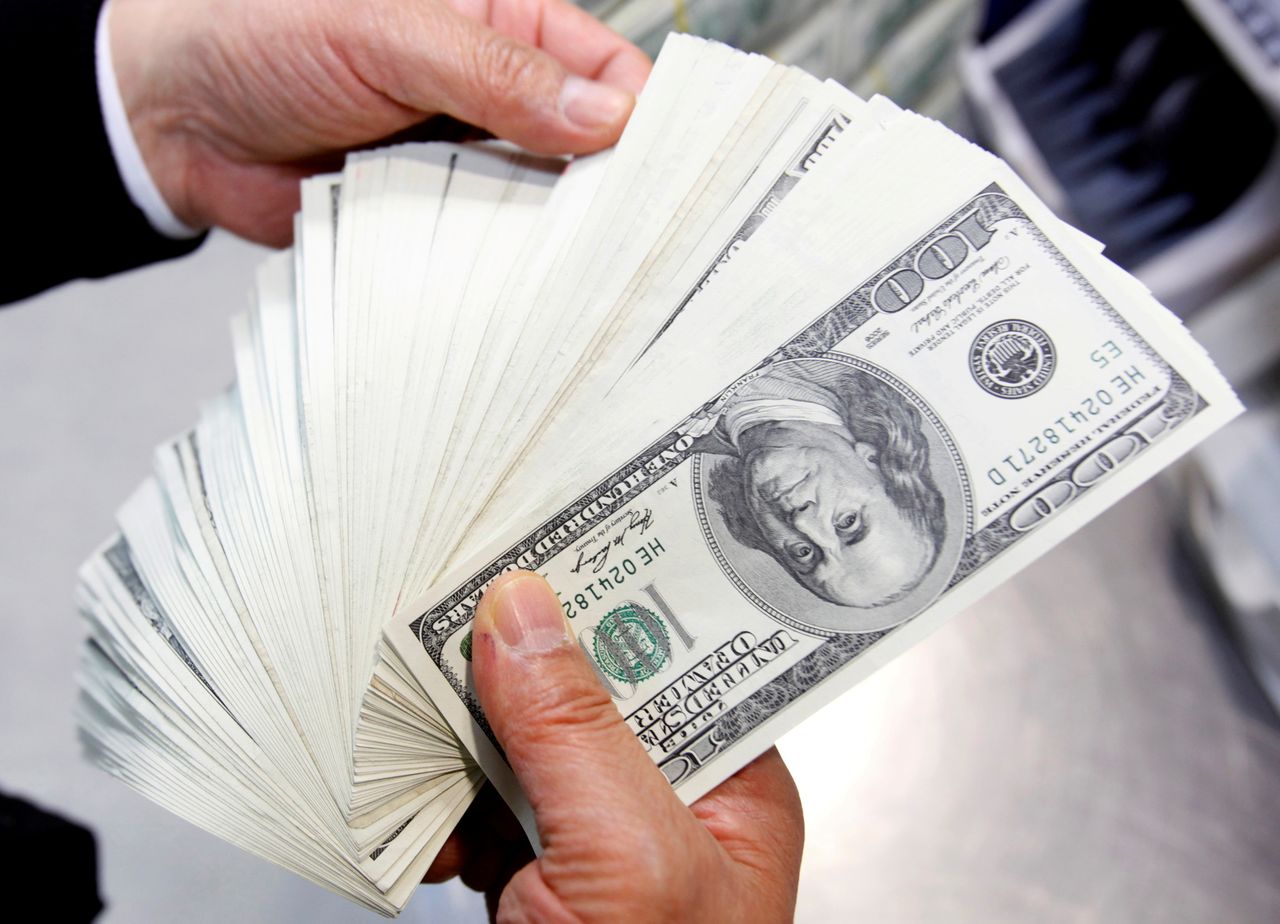 FILE PHOTO: An employee of the Korea Exchange Bank counts one hundred U.S. dollar notes during a photo opportunity at the bank