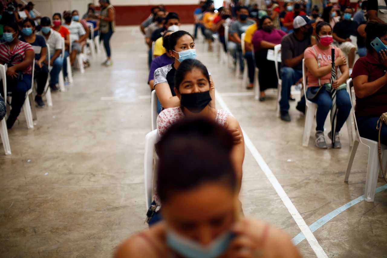 FILE PHOTO: People wait after receiving a dose of the Pfizer-BioNTech coronavirus disease (COVID-19) vaccine during a mass vaccination program for people over 18 years of age at a gym in Praxedis G. Guerrero, Mexico July 10, 2021. REUTERS/Jose Luis Gonzalez