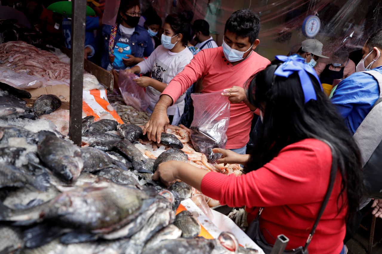 FILE PHOTO: People select fish at a stall of La Viga fish market during the outbreak of the coronavirus disease (COVID-19), in Mexico City, Mexico April 1, 2021. REUTERS/Luis Cortes/File Photo