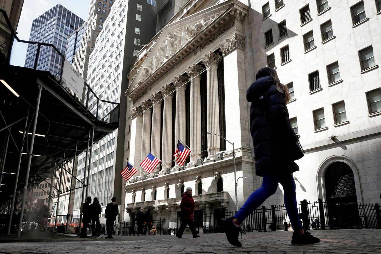 FILE PHOTO: People are seen on Wall Street outside the New York Stock Exchange (NYSE) in New York City, U.S., March 19, 2021. REUTERS/Brendan McDermid/File Photo