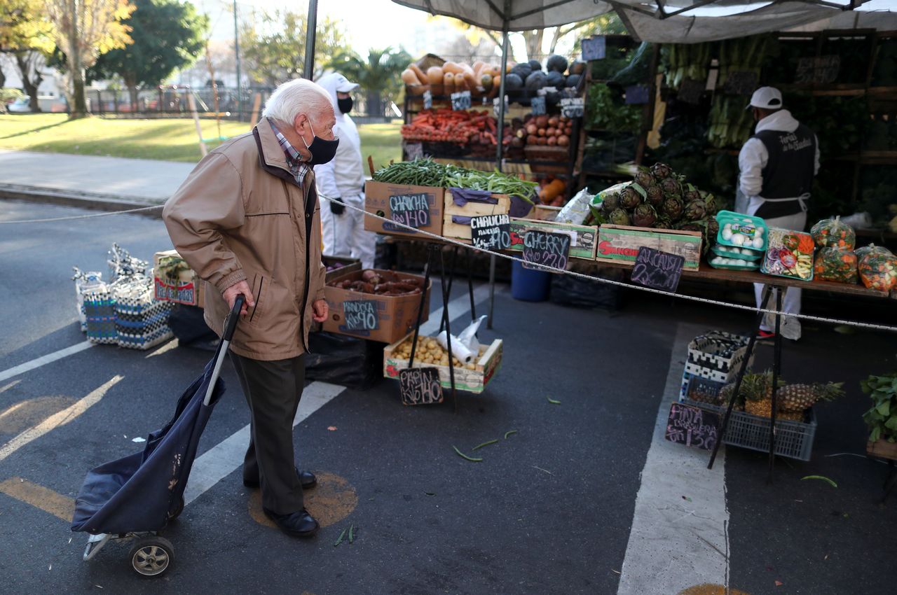 FILE PHOTO: A customer walks outside a shop at a greengrocery store in a street market, in Buenos Aires, Argentina June 15, 2021. REUTERS/Agustin Marcarian