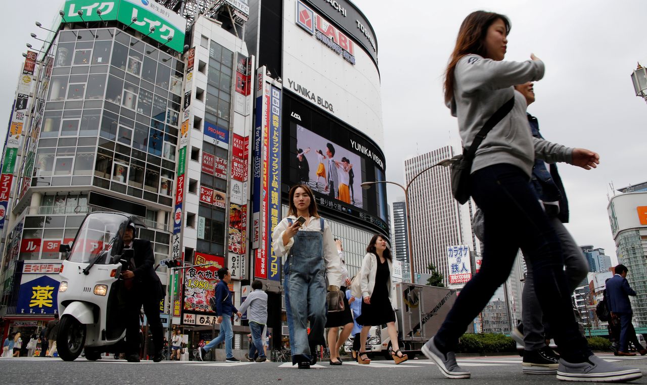 FILE PHOTO: People cross a street in the Shinjuku shopping and business district in Tokyo, Japan May 17, 2017. REUTERS/Toru Hanai
