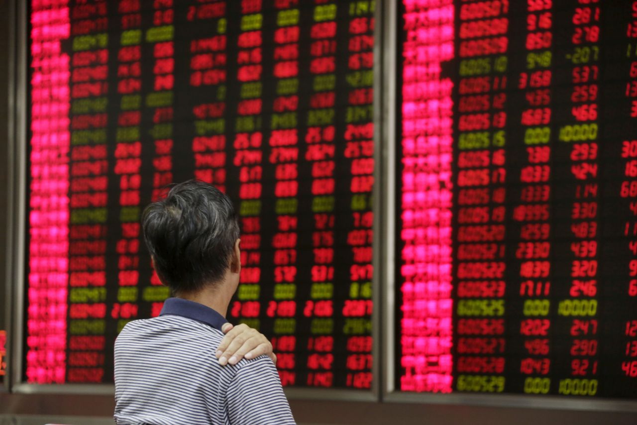 FILE PHOTO: An investor looks at an electronic board showing stock information at a brokerage house in Beijing, August 27, 2015. REUTERS/Jason Lee/File Photo